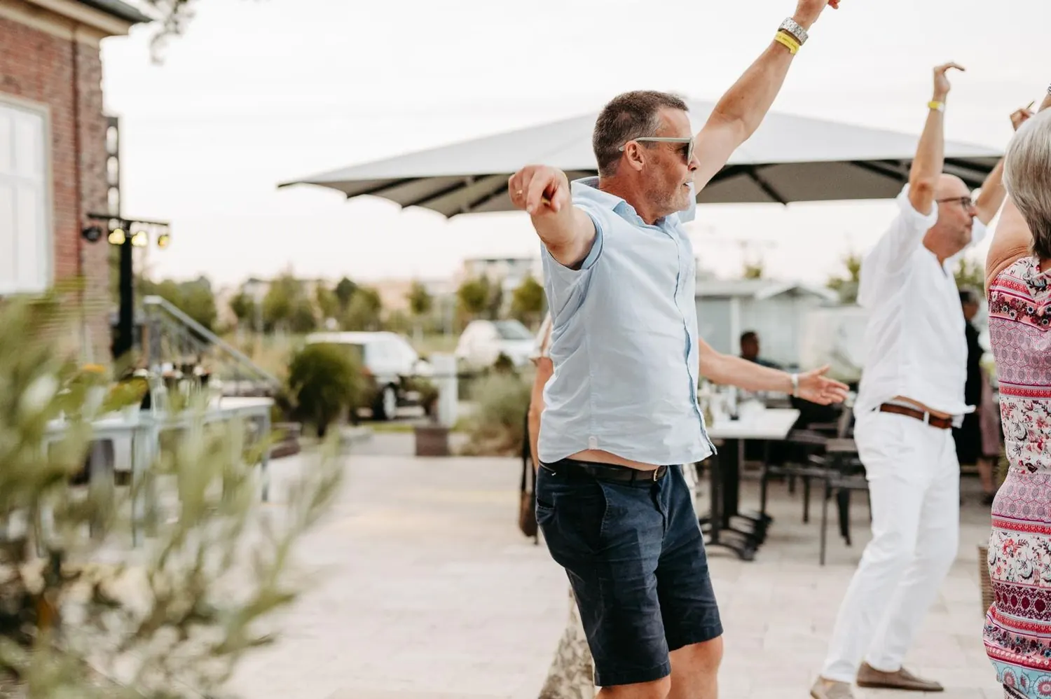 Gäste tanzen ausgelassen auf einer Terrasse im Freien