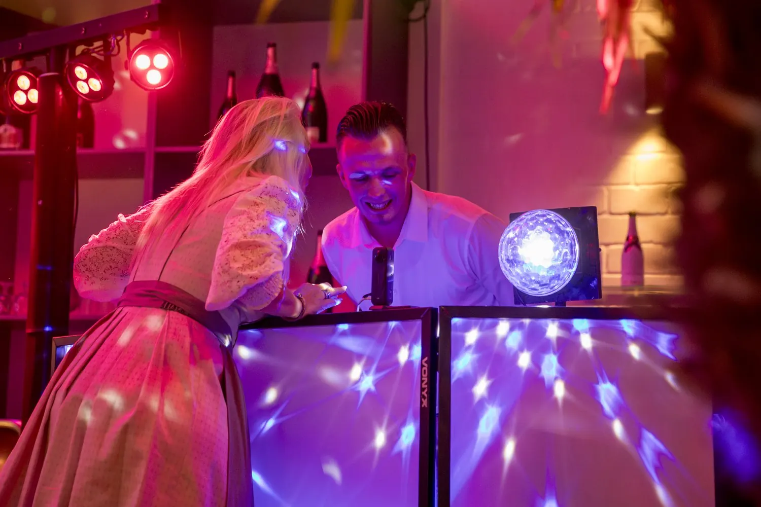 Ein Gast kommt mit einem Musikwunsch zu DJ Nick Baumgarten ans Pult
