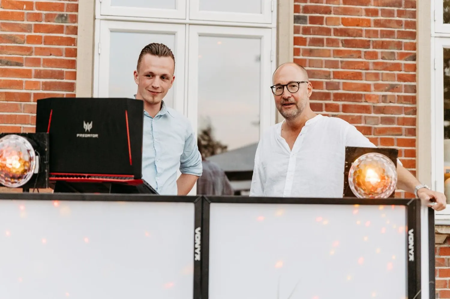 DJ Nick Baumgarten stimmt sich am DJ-Pult mit dem Gastgeber ab
