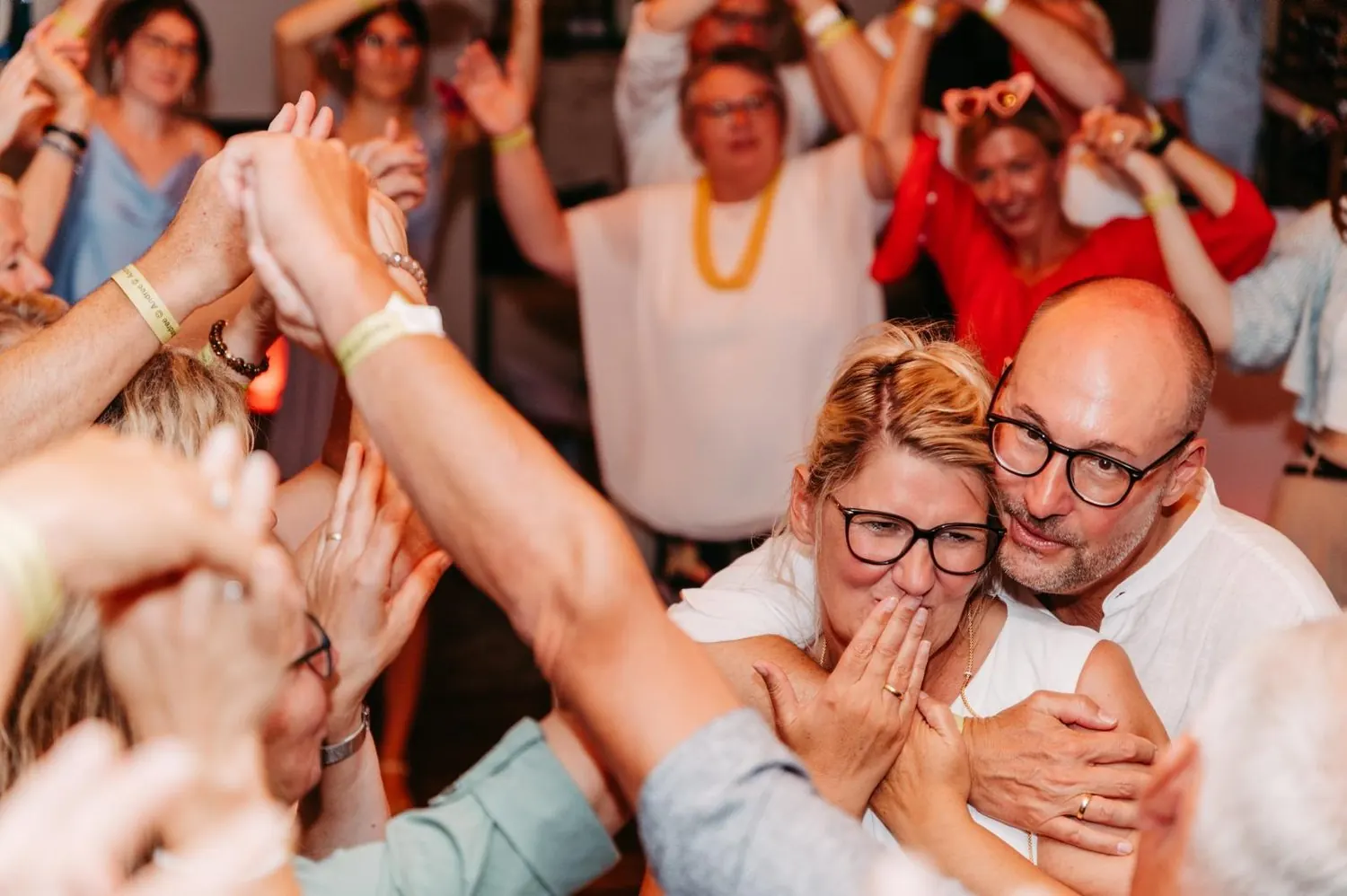 Ein Paar liegt sich auf der Tanzfläche in den Armen, um sie herum feiern die Gäste
