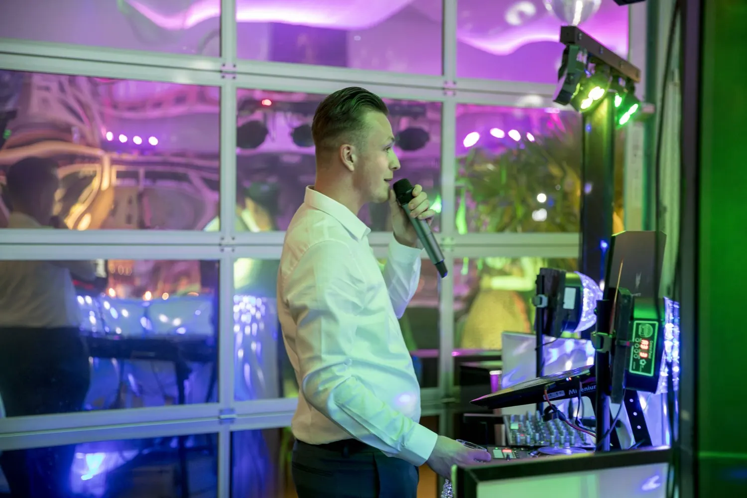 Hochzeits-DJ Nick Baumgarten spricht am DJ-Pult ins Mikrofon